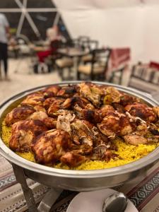 een pan gevuld met vlees en rijst op een tafel bij White Desert Camp in Wadi Rum