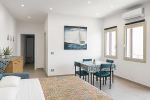 a bedroom with a bed and a table and chairs at RineddaHouse Arenella - Vista Mare Panoramica a Palermo con Parcheggio privato in Palermo