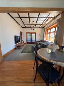 una sala de estar con una mesa y un sofá en Chic 4 bedroom City Home with large Garden, en Palmerston North
