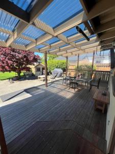 Una terraza de madera con pérgola y mesas de picnic. en Chic 4 bedroom City Home with large Garden, en Palmerston North 8 fotos más