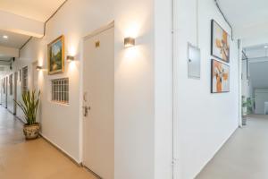 un couloir avec des murs blancs et une porte blanche dans l'établissement Via Ashiyana Inn, à Patna