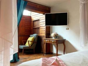 Schlafzimmer mit einem Schreibtisch, einem TV und einem Stuhl in der Unterkunft Seven Senses Guesthouse in Chiang Mai