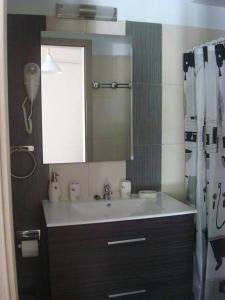 a bathroom with a sink and a mirror at Smaragdi Studios and Rooms in Agios Kirykos