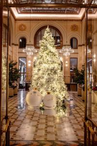 un árbol de Navidad en el vestíbulo de un edificio en The Marmorosch Bucharest, Autograph Collection, en Bucarest