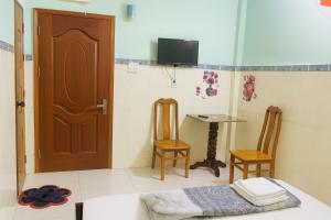 una habitación con una puerta y una mesa y sillas en Cường Phú Hotel Hồ Chí Minh, en Ho Chi Minh