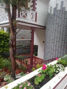 um jardim em frente a um prédio com flores em Sunshine Royale em Kodaikānāl