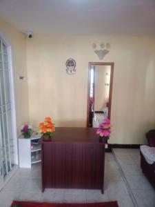 uma sala de estar com uma escrivaninha com flores em Sunshine Royale em Kodaikānāl