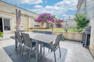 a wooden table and chairs on a patio at L'envie Eymet in Eymet