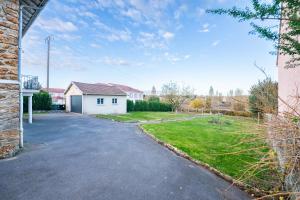 une allée vide dans une cour avec une maison blanche dans l'établissement Chez papa - 3 lits - Confortable & spacieux, à La Ferté-Gaucher