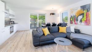 un salon avec un canapé bleu et une cuisine dans l'établissement Ferienhaus Klopeiner See, à Unterburg am Klopeiner See