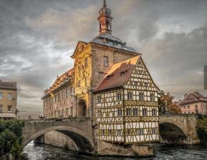 ein Gebäude mit einem Uhrturm auf einer Brücke in der Unterkunft Ü Villa 2 Etagen 5 Schlafzimmer in Hirschaid