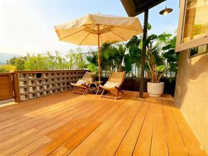 un patio con sombrilla y sillas en una terraza en Hill Design Hotel 山丘设计师酒店 春熙路太古里店, en Chengdú