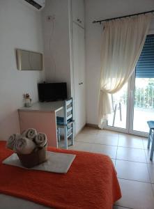 a room with a bed and a desk and a window at Smaragdi Studios and Rooms in Agios Kirykos