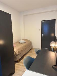 a room with a bed and a table and chairs at Pension Moerdijk in Moerdijk