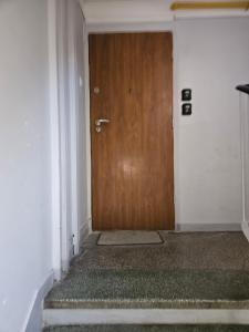 a wooden door in a white room with a stair at Apartly - City Home &B in Szczecin