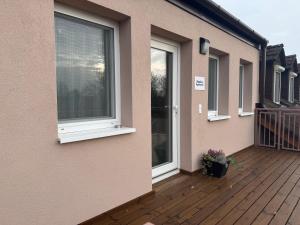 ein Balkon eines Hauses mit Fenstern und einer Terrasse in der Unterkunft Napfény Apartman in Marcali