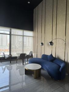 a living room with a blue couch and a table at Urban Suites Staycation Spot by Twinkle Loft in George Town