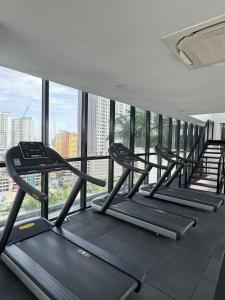 a row of treadmills in a gym with windows at Urban Suites Staycation Spot by Twinkle Loft in George Town +21 photos