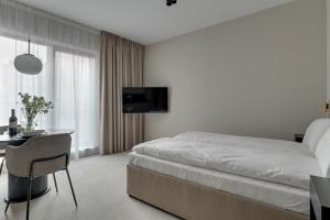 a bedroom with a bed and a table and a tv at GRANO APARTMENTS Gdańsk Granaria in Gdańsk