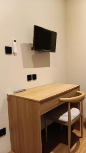 a wooden desk with a television on a wall at First Kost Seturan 32 in Yogyakarta +6 photos