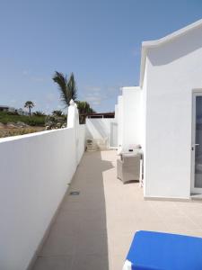 a white house with a white wall and a patio at Ferienwohnung Luna in Charco del Palo