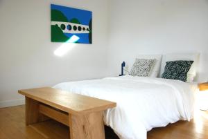a bedroom with a white bed and a wooden table at Charmante maison 2 chambres et parking privé in Fleurey-sur-Ouche