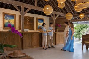a group of people standing around a bar in a restaurant at Seven Dreams A Pramana Experience in Nusa Penida