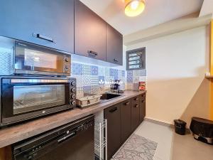 圣玛丽Bleu des Ô - Maison de 66m2 avec jacuzzi et sauna的配有微波炉和水槽的厨房