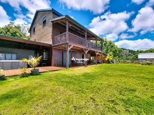 圣玛丽Bleu des Ô - Maison de 66m2 avec jacuzzi et sauna的前面有大院子的房子