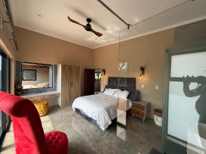 a bedroom with a bed and a glass door with a camera at Blessed Lodge at Ingilozi Mabalingwe in Warmbaths +39 photos
