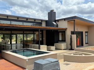 a house with a swimming pool in front of it at Blessed Lodge at Ingilozi Mabalingwe in Warmbaths
