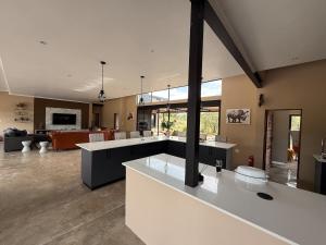a large living room with a kitchen and a living room at Blessed Lodge at Ingilozi Mabalingwe in Warmbaths