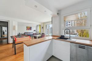 eine Küche und ein Wohnzimmer mit einem Tisch und einer Couch in der Unterkunft Le Sportif - Montrouge in Montrouge + 6 Fotos