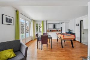 ein Wohnzimmer mit einer Couch, einem Tisch und einer Küche in der Unterkunft Le Sportif - Montrouge in Montrouge