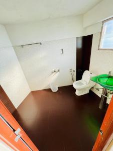 ein Badezimmer mit Toilette und Waschbecken in der Unterkunft Oval Retreat in Kochi