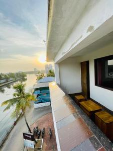 einen Balkon eines Gebäudes mit Blick auf ein Boot in der Unterkunft Oval Retreat in Kochi
