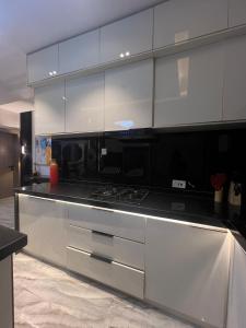 a kitchen with a stove and white cabinets at Urban Muse in Lekki +10 photos