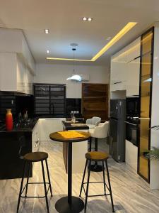 a kitchen with a table and some stools in it at Urban Muse in Lekki