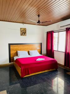 ein Schlafzimmer mit einem großen Bett mit einer roten Decke in der Unterkunft Oval Retreat in Kochi + 11 Fotos