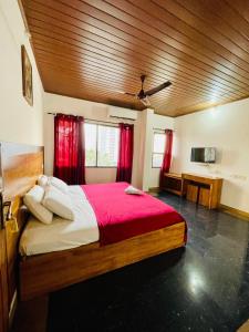 ein Schlafzimmer mit einem großen Bett mit roten Vorhängen in der Unterkunft Oval Retreat in Kochi