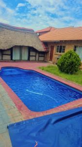 una piscina azul frente a una casa en Luxurious Family Carven!, en Rustenburg
