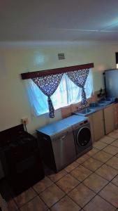 cocina con lavadora y ventana en Luxurious Family Carven!, en Rustenburg