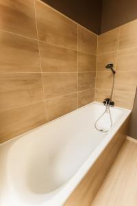 eine weiße Badewanne in einem Zimmer mit Holzwänden in der Unterkunft Ma Montagne Chic 2 in La Bresse + 7 Fotos