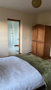 a bedroom with a large bed and a dresser at Kilohill House in Ballyvaughan +2 photos