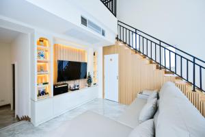 a living room with a couch and a television at Santara Pool Villa Udon in Udon Thani
