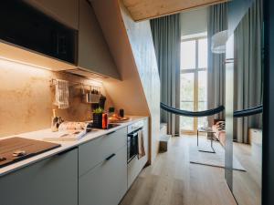 a kitchen with white cabinets and a large window at Sume by Larsen in Tallinn