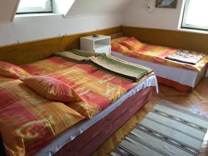 two twin beds sitting in a room with at Tóni Bácsi Üdülő in Mezőkövesd