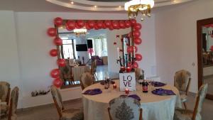une table dans une pièce avec des ballons rouges et un miroir dans l'établissement Pensiunea Alexandra, à Predeal