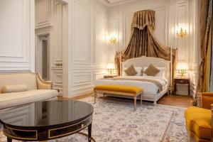 a bedroom with a king sized bed and a coffee table at The Bentley Luxury Hotel & Suites in Doha +136 photos
