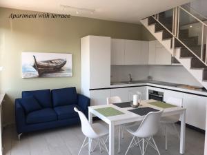 a kitchen with a blue couch and a table and chairs at Tower 44 in Luino